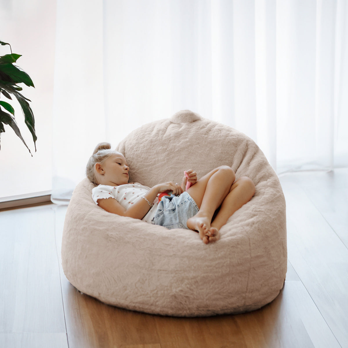 Child curled up in a DreamPod Mini bean bag chair